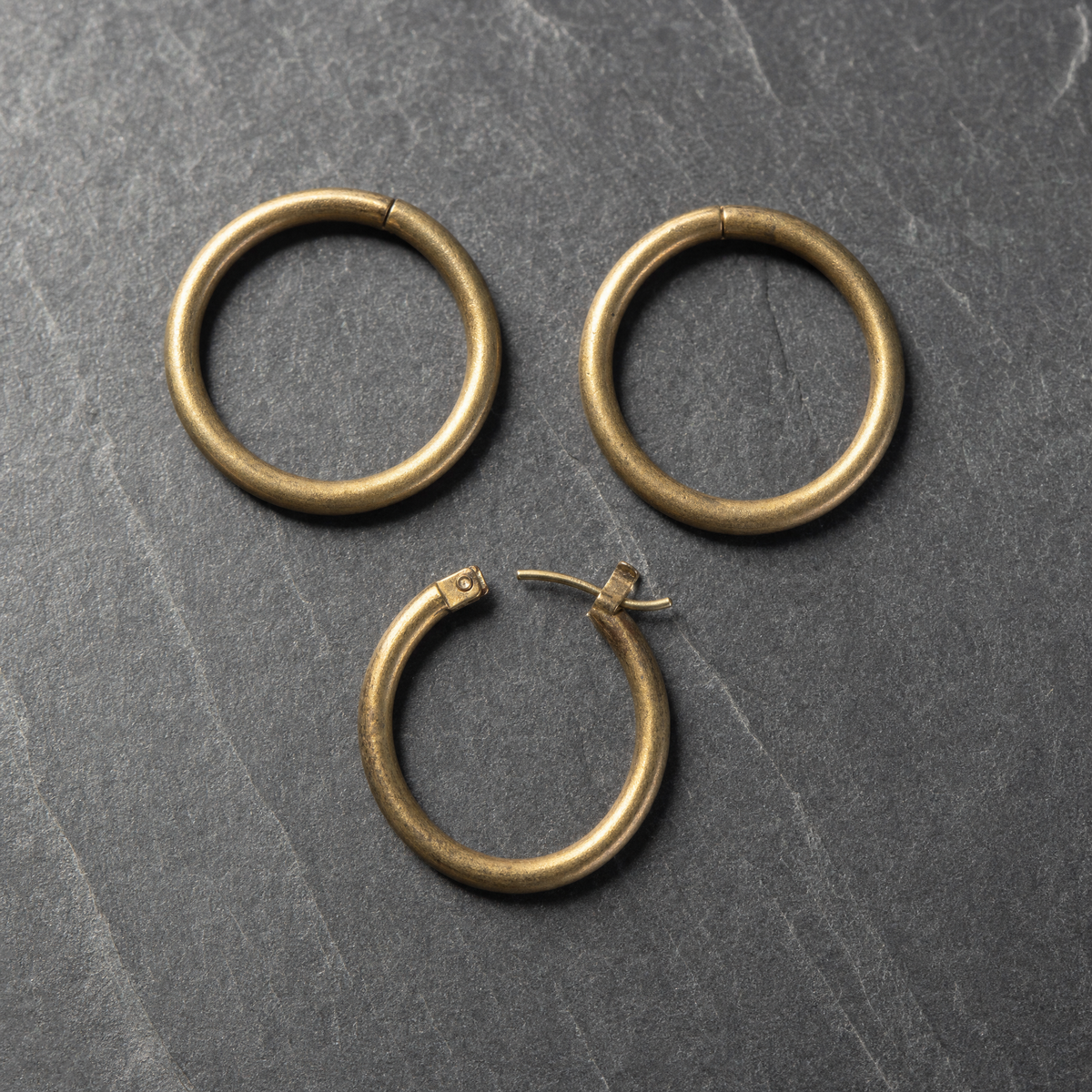 Polished brass earring hoops with the hinged catch visible on one