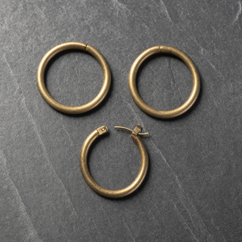 Polished brass earring hoops with the hinged catch visible on one
