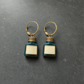 A pair of teal enamelled brass ink bottle charm earrings on dark slate