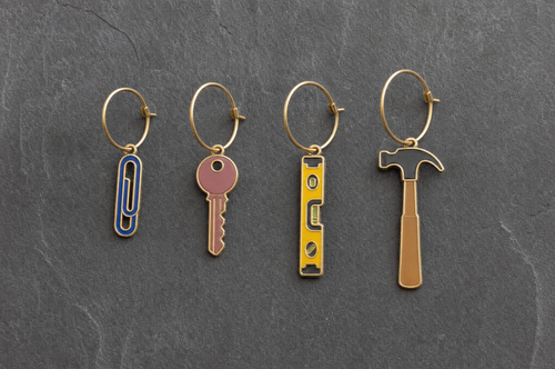 Paperclip, key, spirit level and claw hammer charms in a row at the same scale