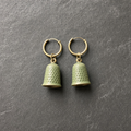 A pair of sage green enamelled brass thimble charm earrings on brass hoops, on dark slate