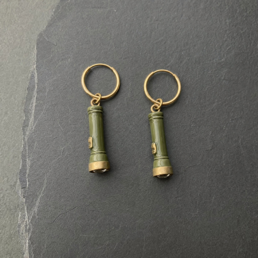 A pair of olive green enamelled brass pocket torch charm earrings on dark slate